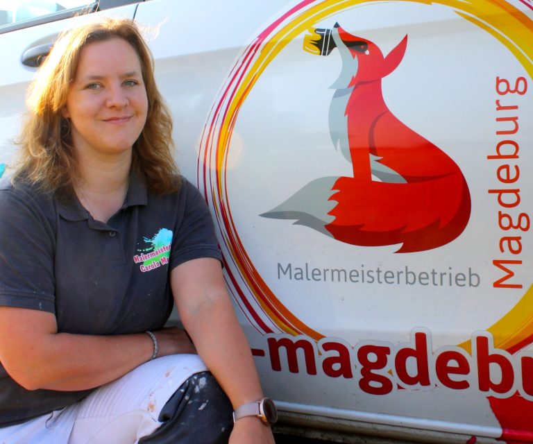 Malermeisterin Magdeburg vor dem Firmenfahrzeug mit Logo